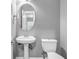 Cozy powder room with pedestal sink, oval mirror, and neutral wall color at 1714 Boulder Walk Se Ln, Atlanta, GA 30316