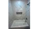 Elegant bathroom featuring a bathtub with a decorative tiled wall and a built-in shelf at 1766 Venetian Sw Dr, Atlanta, GA 30311