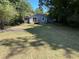 Charming single-story home with light blue siding, a wooden deck, and a spacious grassy front yard surrounded by mature trees at 1766 Venetian Sw Dr, Atlanta, GA 30311