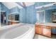 Soaking tub bathroom with large mirror, wallpaper and oak vanity at 227 Eton Ct, Mableton, GA 30126