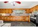 Well-lit kitchen featuring knotty pine cabinets, tile backsplash and slate tile floors at 474 Upper Burris Rd, Canton, GA 30114