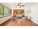Sunlit living room featuring a brick accent wall, hardwood floors, and neutral furniture at 474 Upper Burris Rd, Canton, GA 30114