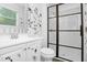 Bathroom with a glass door shower and a stylish white vanity with floral decals at 6625 Peppermill Ln, South Fulton, GA 30349