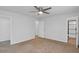 Spacious bedroom with ceiling fan, carpet, and access to both closet and bathroom at 6625 Peppermill Ln, South Fulton, GA 30349
