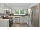 Updated kitchen with stainless steel appliances, bright cabinets, and a decorative backsplash at 6625 Peppermill Ln, South Fulton, GA 30349