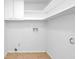 Bright utility room featuring white cabinets, shelves, and tile flooring at 6625 Peppermill Ln, South Fulton, GA 30349