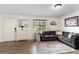 Cozy living area featuring hardwood floors, grey sofa, and lots of natural light at 6900 Roswell Rd # 3N, Atlanta, GA 30328