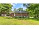 View of the back exterior of the house and wooden deck with an expansive backyard and a blue sky at 765 Shellnut Dr, Forest Park, GA 30297