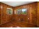 Bedroom featuring wood paneled walls, hardwood floors, and two windows at 765 Shellnut Dr, Forest Park, GA 30297
