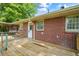 View of a wooden deck attached to a brick home with a white door and window features at 765 Shellnut Dr, Forest Park, GA 30297
