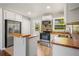 Bright kitchen with wood counters, stainless appliances, an island bar, and new flooring at 765 Shellnut Dr, Forest Park, GA 30297