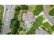 An aerial perspective of a backyard with a pool, patio, and lush landscaping next to a road at 100 Braxton Way, Roswell, GA 30075