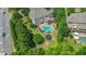 Aerial view showcasing the large backyard with a pool, spa, patio, and trampoline surrounded by lush trees at 100 Braxton Way, Roswell, GA 30075