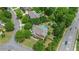 Aerial view showcasing a home with a backyard pool, patio, lush landscaping, and surrounding greenery at 100 Braxton Way, Roswell, GA 30075