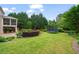Expansive backyard featuring green grass, trampoline, landscaping, and screened porch at 100 Braxton Way, Roswell, GA 30075