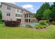 Lush backyard with a pool, landscaped garden beds, and an expansive lawn and mature trees at 100 Braxton Way, Roswell, GA 30075