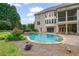 Expansive backyard featuring a swimming pool, spa, covered patio and lush landscaping at 100 Braxton Way, Roswell, GA 30075