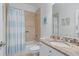 Cozy bathroom featuring a shower with a blue and white shower curtain, and granite countertops at 100 Braxton Way, Roswell, GA 30075
