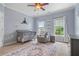 Cozy Bedroom featuring a crib, glider, neutral walls, and bright windows that provide natural light at 100 Braxton Way, Roswell, GA 30075