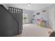 Charming bedroom featuring a built-in bunk bed with stairs and whimsical dinosaur wall decor at 100 Braxton Way, Roswell, GA 30075