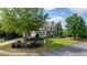 Beautiful home exterior with lush landscaping, mature trees, and a well-maintained lawn at 100 Braxton Way, Roswell, GA 30075