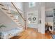Bright foyer featuring a staircase, hardwood floors, high ceilings, white trim, and a charming bench at 100 Braxton Way, Roswell, GA 30075