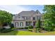 Beautiful two-story home featuring a brick facade, manicured lawn, covered porch, and symmetrical design at 100 Braxton Way, Roswell, GA 30075