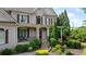 Charming home with a covered porch, brickwork, decorative shutters, and well-maintained landscaping at 100 Braxton Way, Roswell, GA 30075