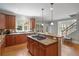 Large kitchen with a stovetop island, view of the stairs, and stone countertops at 100 Braxton Way, Roswell, GA 30075
