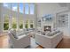 Bright living room with a fireplace, built-in shelves, tall windows, and comfortable seating at 100 Braxton Way, Roswell, GA 30075
