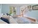 Bright living room with a large window and a view of the staircase with a light blue accent wall at 100 Braxton Way, Roswell, GA 30075