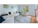 Bright living room with hardwood floors, white furniture, and soft blue walls at 100 Braxton Way, Roswell, GA 30075