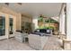 Inviting covered patio featuring comfortable seating, with brick accents and lush landscaping at 100 Braxton Way, Roswell, GA 30075
