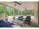 Covered outdoor patio with ceiling fans, comfortable seating, and views of the pool and manicured backyard at 100 Braxton Way, Roswell, GA 30075