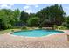 Beautiful backyard pool and spa area with surrounding brick patio, lush greenery, and mature trees at 100 Braxton Way, Roswell, GA 30075