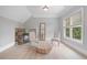 Cozy sitting area featuring a fireplace, mirror, and a large window for natural light at 100 Braxton Way, Roswell, GA 30075