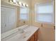 Functional bathroom featuring a large mirror, bright lighting, and white cabinets at 1003 Wiley Bridge Rd, Woodstock, GA 30188