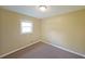 This bedroom is carpeted, painted in neutral colors, and has a window that lets in natural light at 1003 Wiley Bridge Rd, Woodstock, GA 30188
