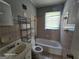 Retro-style bathroom featuring a bathtub, sink, toilet, window, and pink tile at 1243 Hill Nw St, Conyers, GA 30012