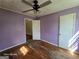 View of bedroom with peeling wood floors, light purple walls, white trim, and two doors at 1243 Hill Nw St, Conyers, GA 30012