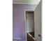 Close up view of a small closet inside a bedroom with peeling wood floors and light purple walls at 1243 Hill Nw St, Conyers, GA 30012