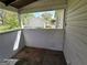 Enclosed patio showing weathered walls and flooring, partially obscuring a view of the adjacent home at 1243 Hill Nw St, Conyers, GA 30012