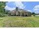 Back of house with large yard, multiple seating areas, chimney, and partial fence at 1815 Sharon Rd, Cumming, GA 30041