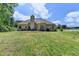 Back of house with large lawn, partial fence, and multiple seating areas at 1815 Sharon Rd, Cumming, GA 30041
