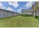 Large backyard with lush green grass, a stone privacy wall, and manicured landscaping surrounding the home at 1815 Sharon Rd, Cumming, GA 30041