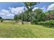 Lush green backyard with mature trees and shed, partially fenced at 1815 Sharon Rd, Cumming, GA 30041