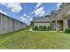 Large backyard with lush green grass, a stone privacy wall, and manicured landscaping surrounding the home at 1815 Sharon Rd, Cumming, GA 30041