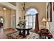 Sunlit foyer area featuring a large round table, arched window, hardwood floors, and neutral wall colors at 1815 Sharon Rd, Cumming, GA 30041