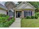 Inviting front entrance with stone accents, a landscaped walkway, and a dark-colored front door at 1815 Sharon Rd, Cumming, GA 30041