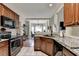 Open kitchen boasts granite countertops and black appliances, overlooking a dining area at 1815 Sharon Rd, Cumming, GA 30041